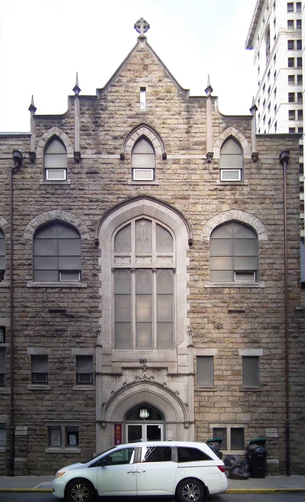 A narrow stone Gothic building on a downtown street