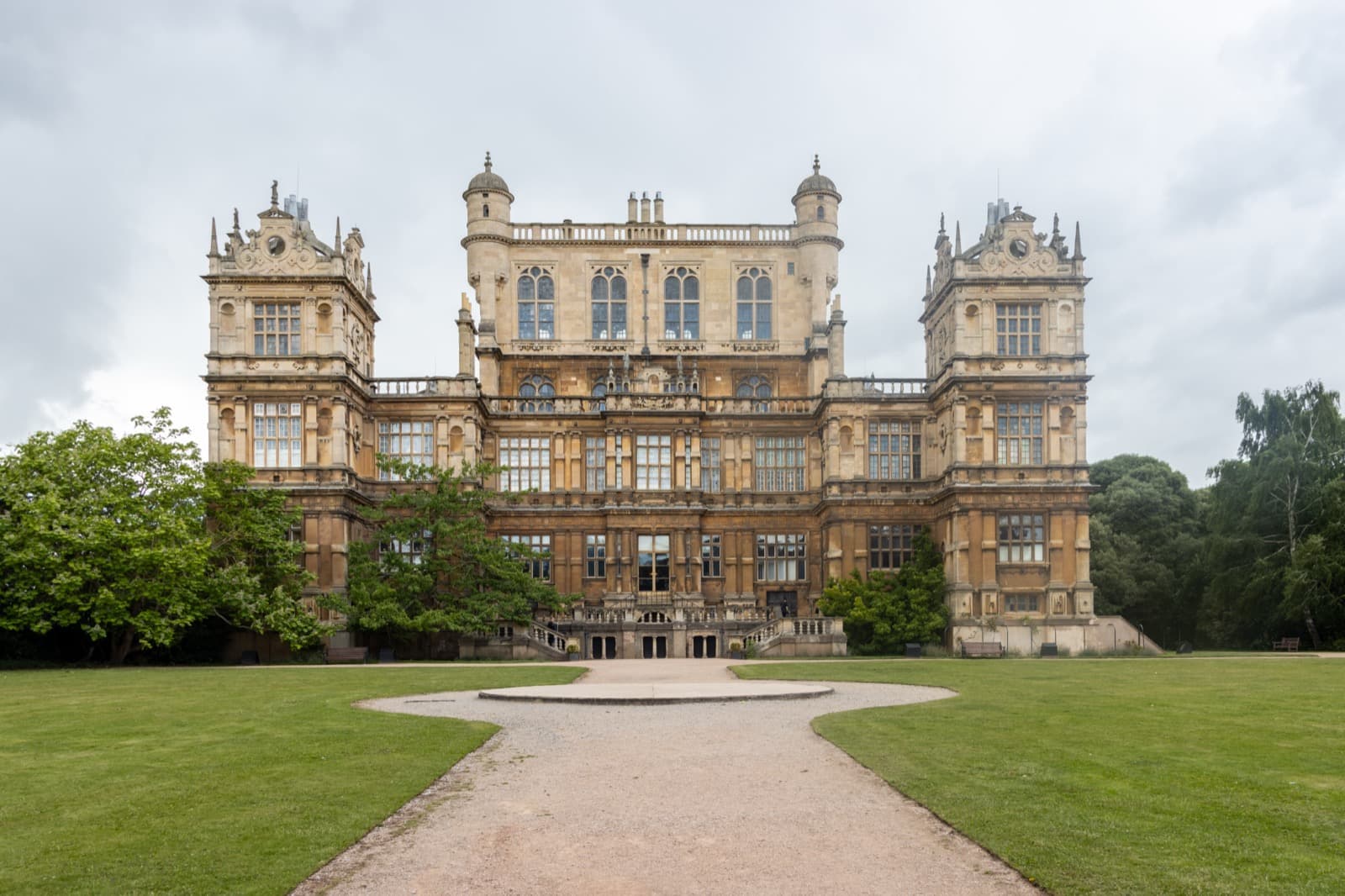 An Elizabethan mansion with corner towers and a raised central hall on a hill