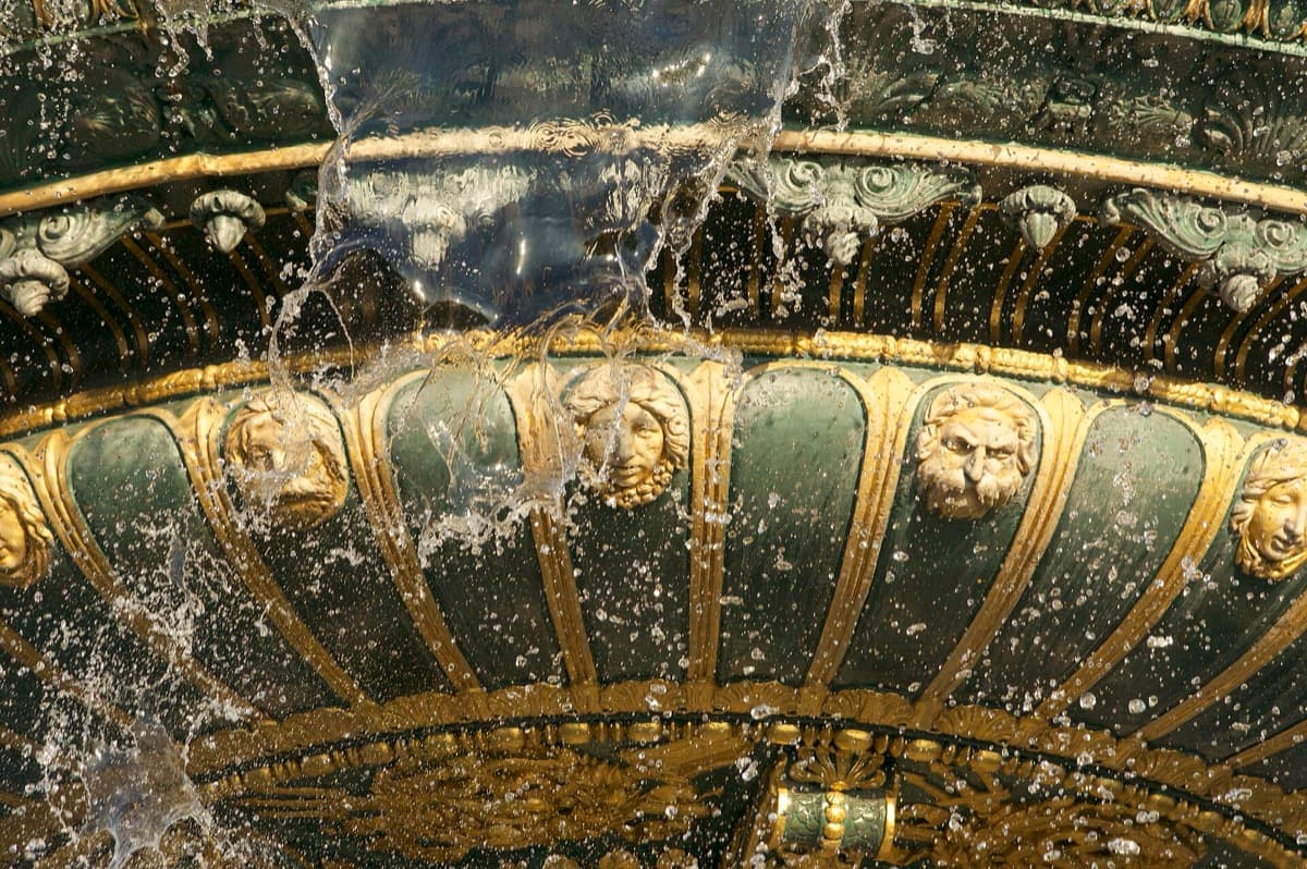 Water spraying from a bronze fountain in a Paris square