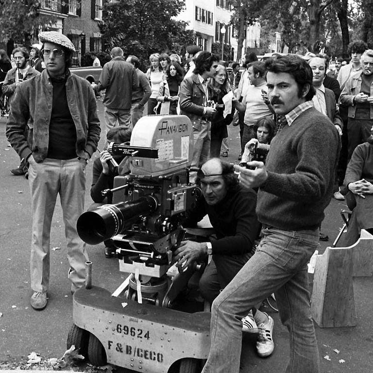 Black-and-white photograph of a film crew with a camera on a street corner