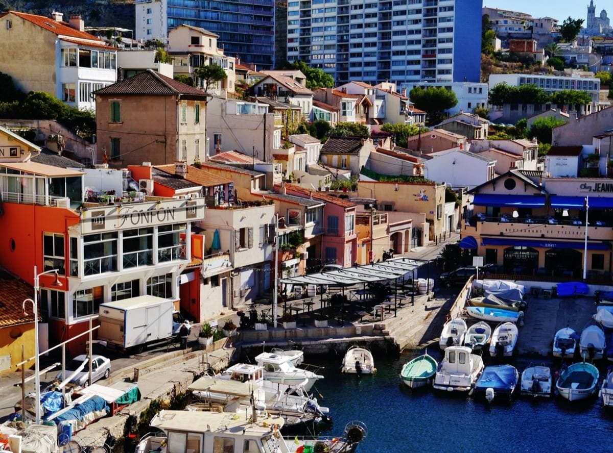A tiny harbour packed with small boats under pastel houses