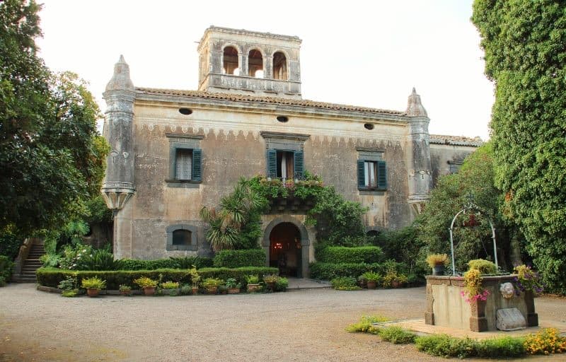 A square baroque villa with a parapet among trees