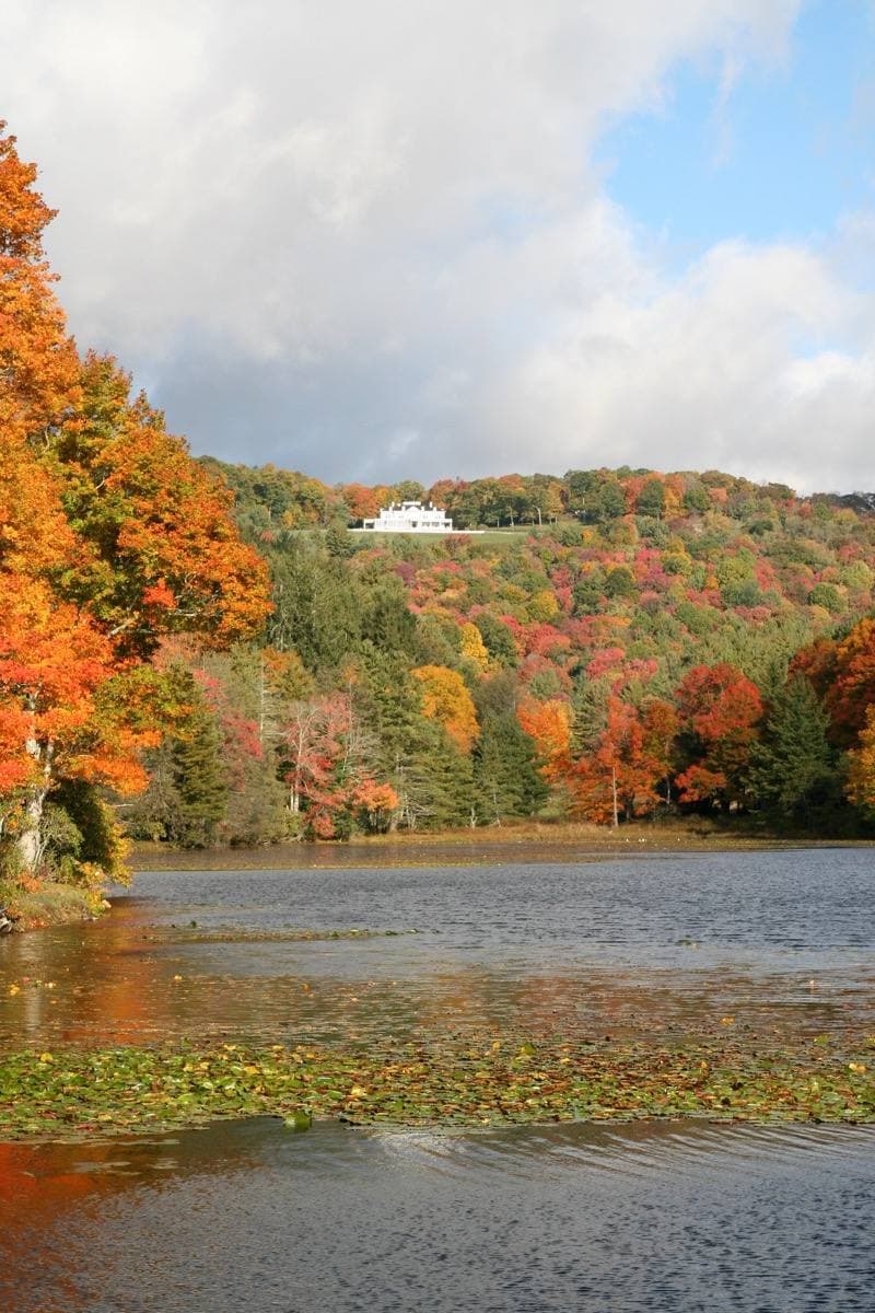 Flat Top Manor on its hill above Bass Lake in autumn