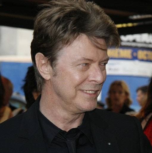 David Bowie smiling, in a black shirt