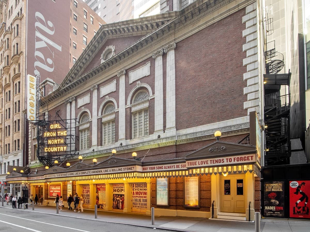 A Broadway theatre front lit at night with its name in lights