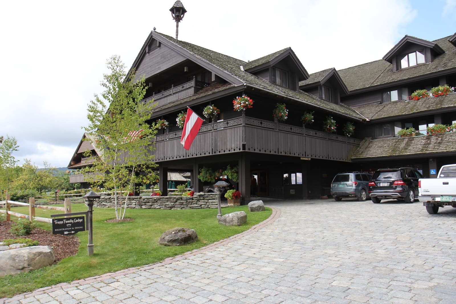 A dark timber alpine lodge with balconies and window boxes