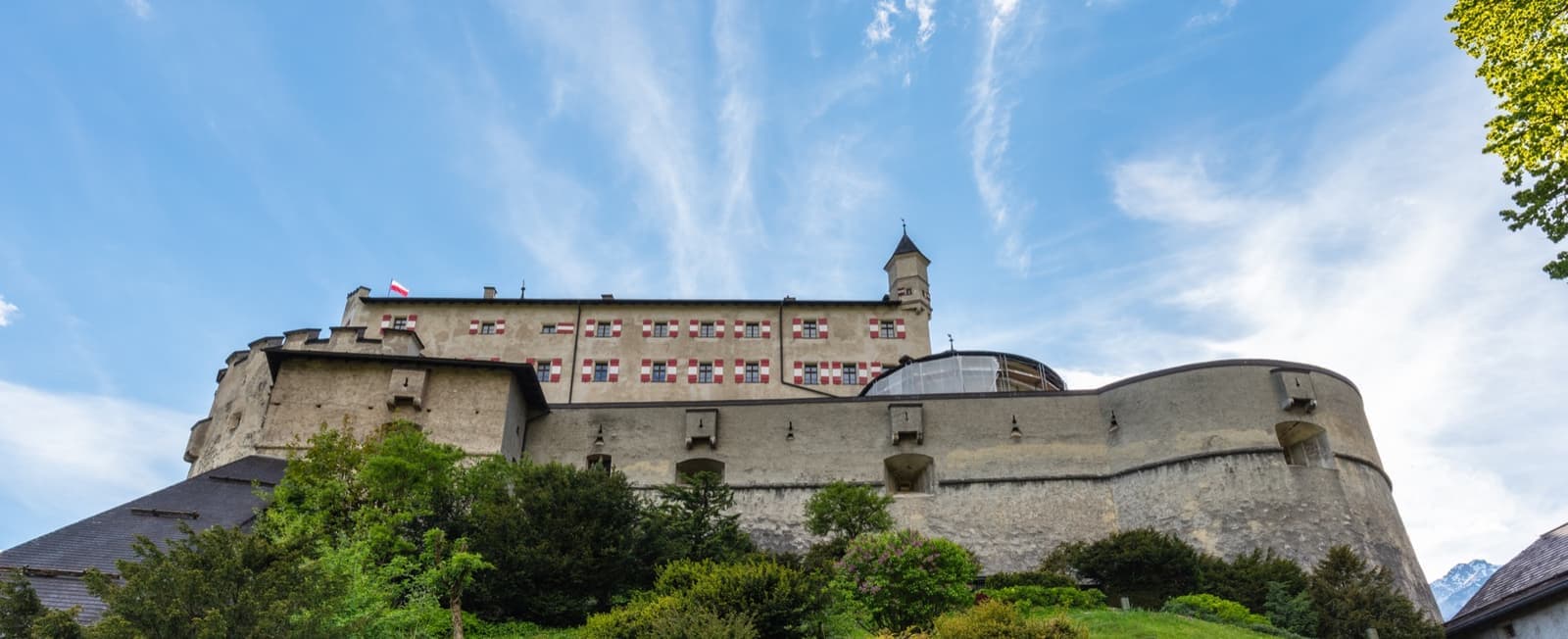 A long stone fortress on a green hill against blue sky