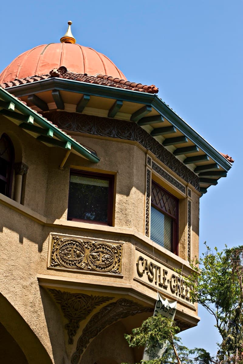 A tall red-brown building with turrets and balconies