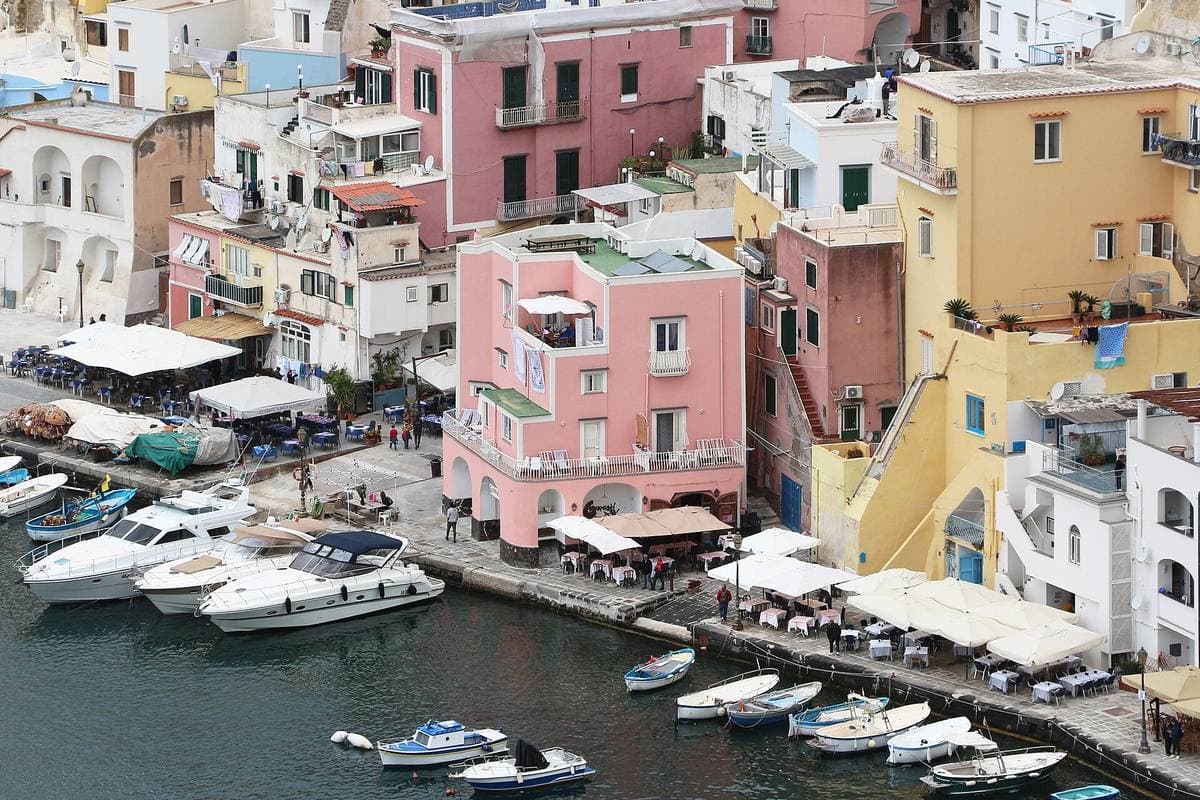 Pink, yellow and white houses with arched stairways above the water