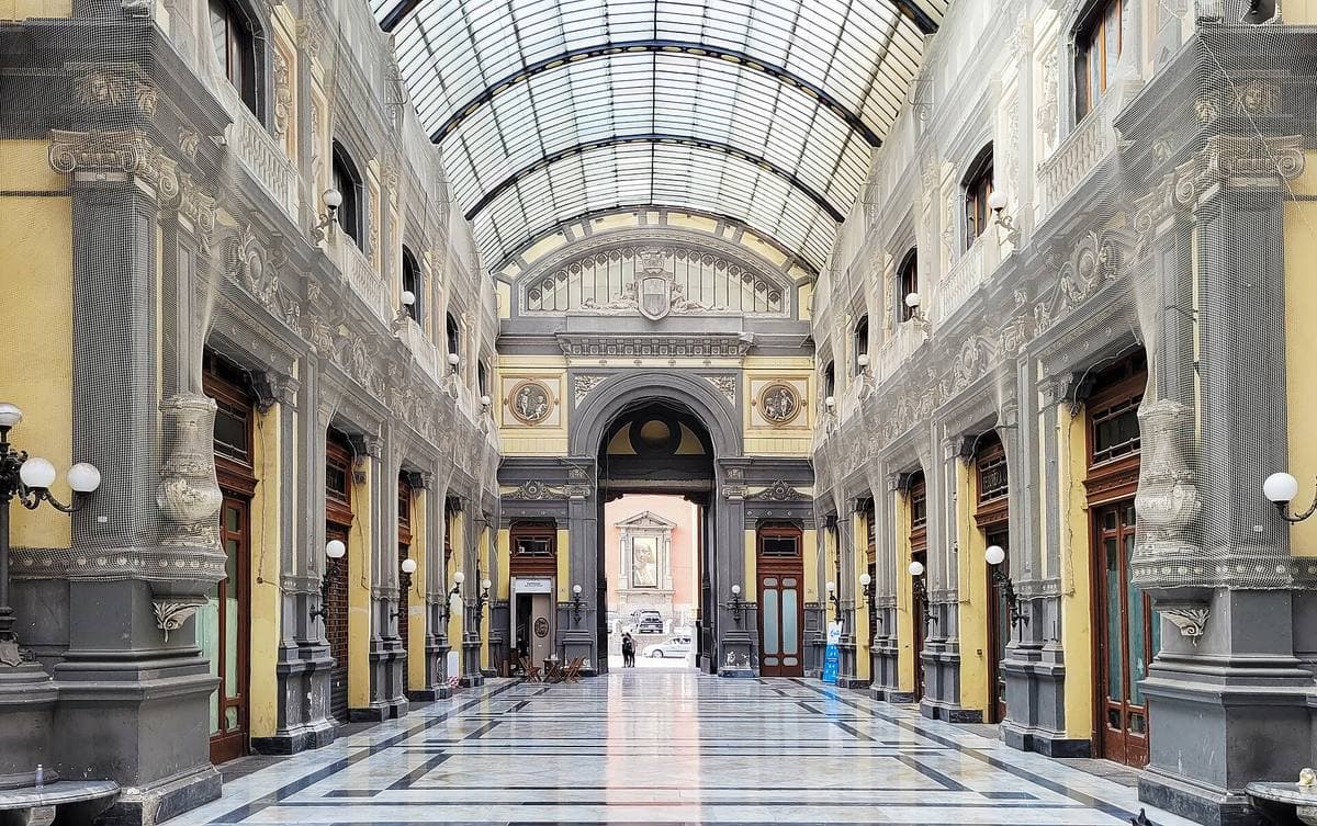 A glass and iron-vaulted shopping arcade with stucco walls