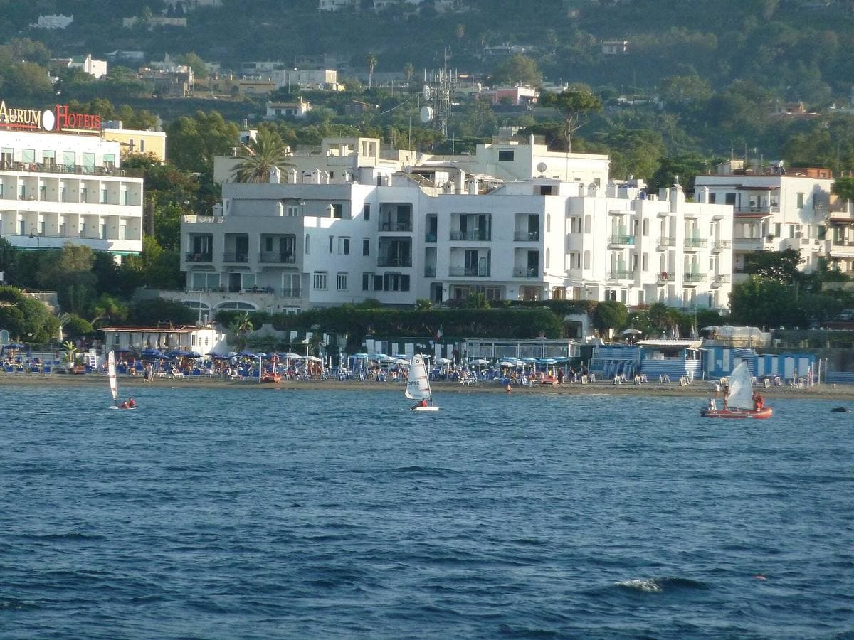 A sandy beach with umbrellas and a calm sea on Ischia