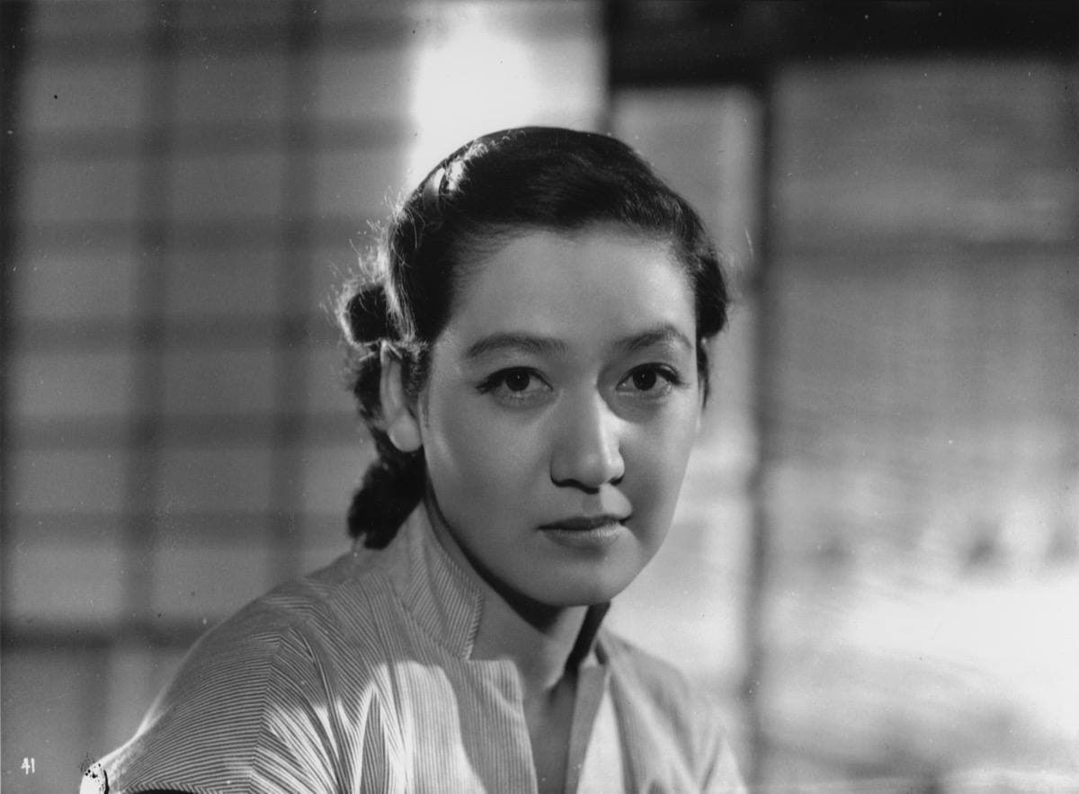 Setsuko Hara in a pale blouse, her hair tied back, looking just past the camera