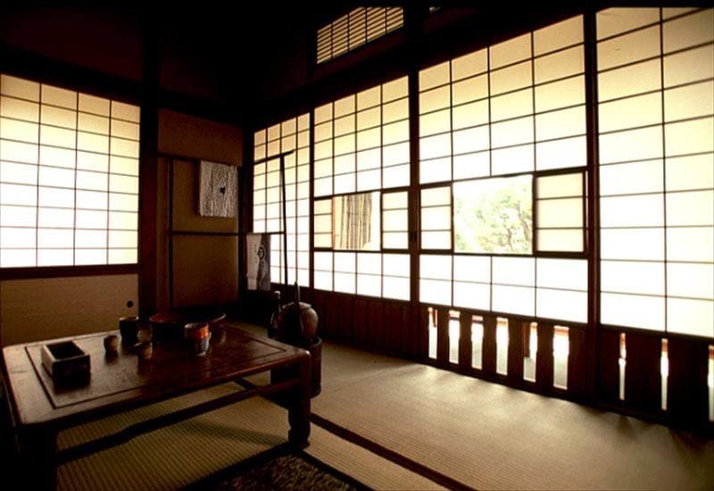 A tatami room with a low table and paper screens lit by daylight