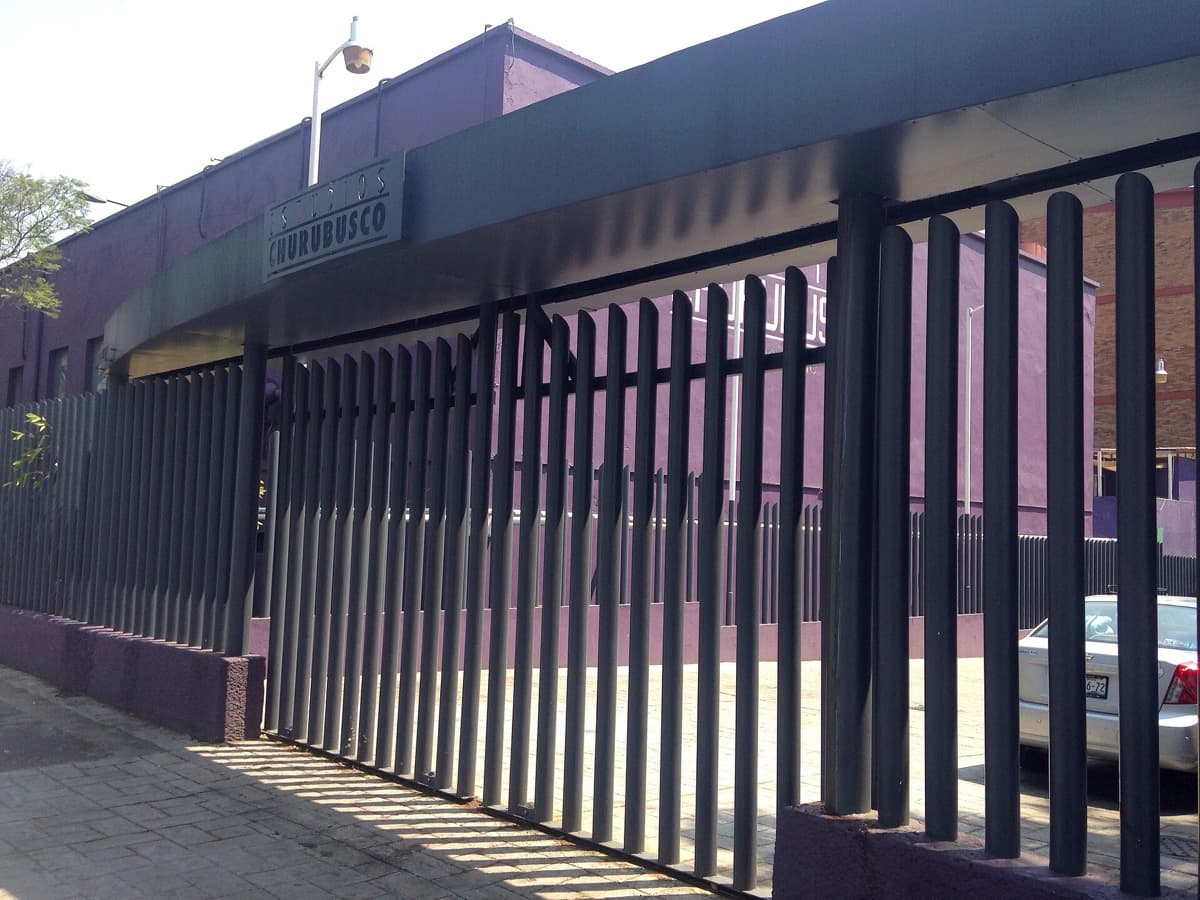A studio gate and low buildings under a blue sky