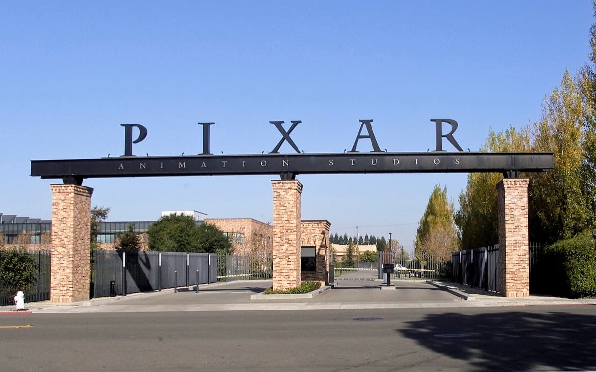 A gated studio entrance with a lamp-post sign and low buildings behind
