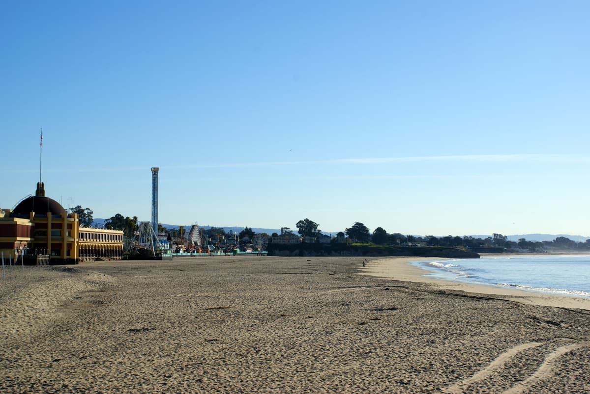 An empty sandy beach at dawn with the surf behind