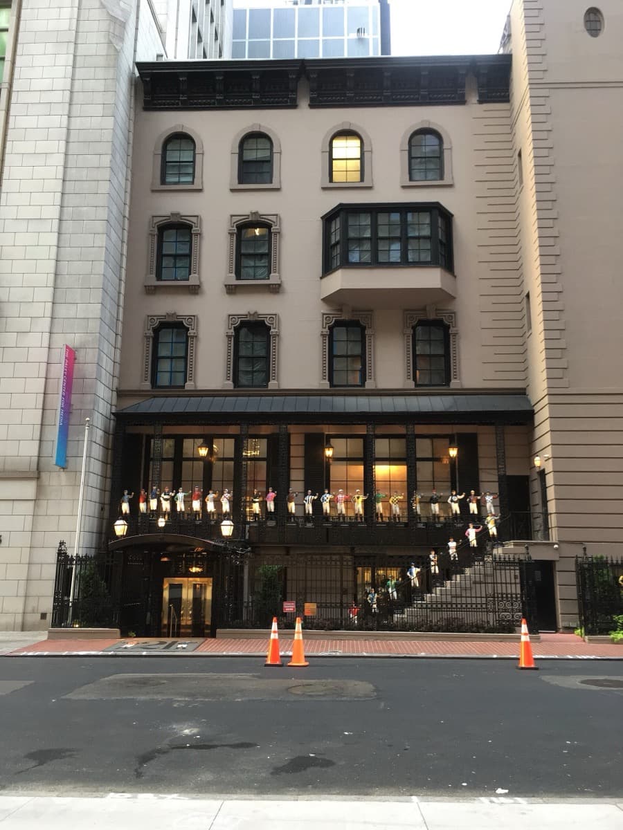A brownstone restaurant front with iron railings and jockey figures