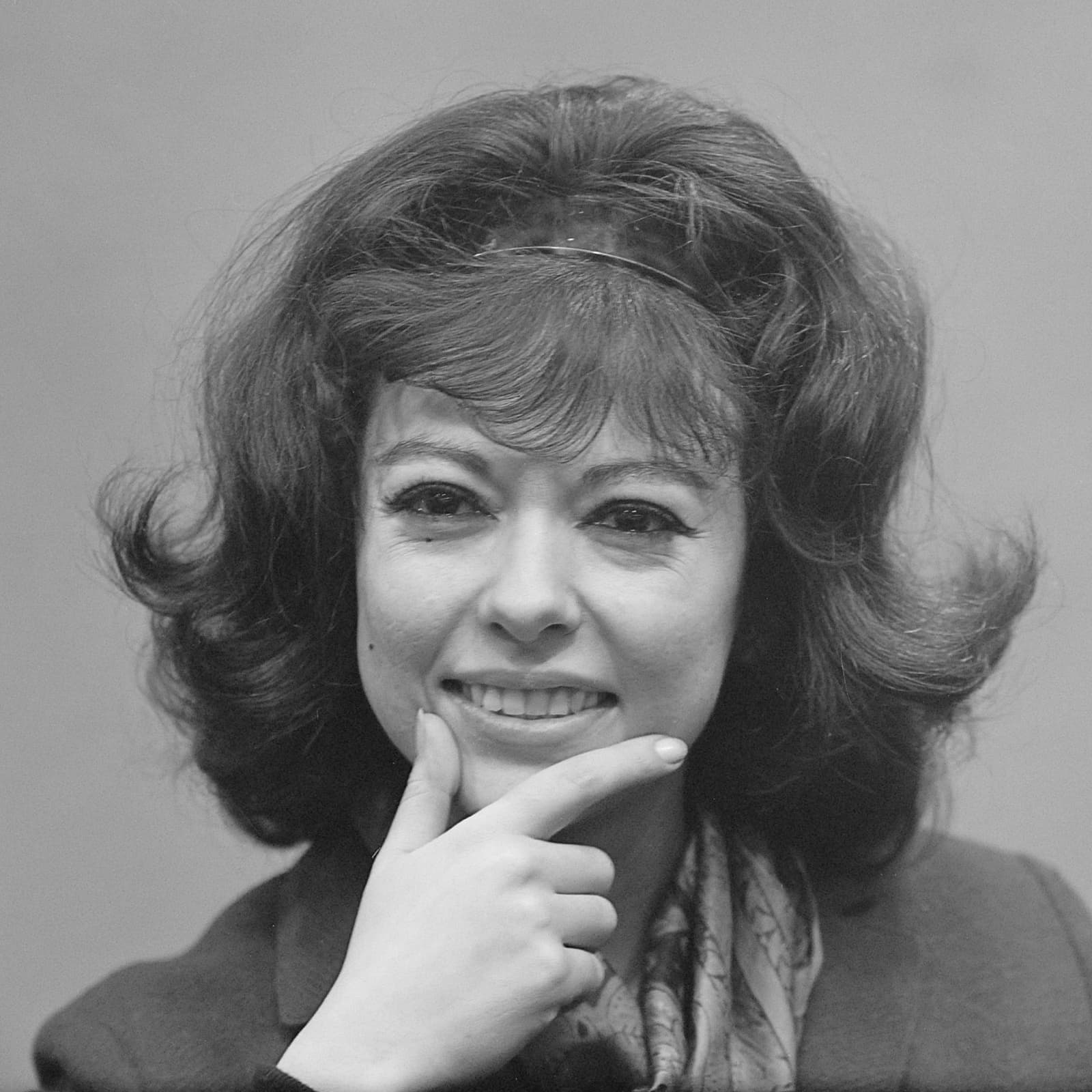 Rita Moreno smiling, chin resting on her hand