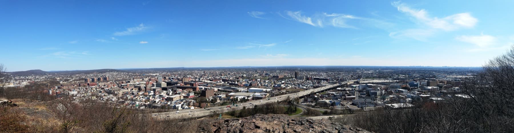 A wide view over the rooftops of a small city under blue sky