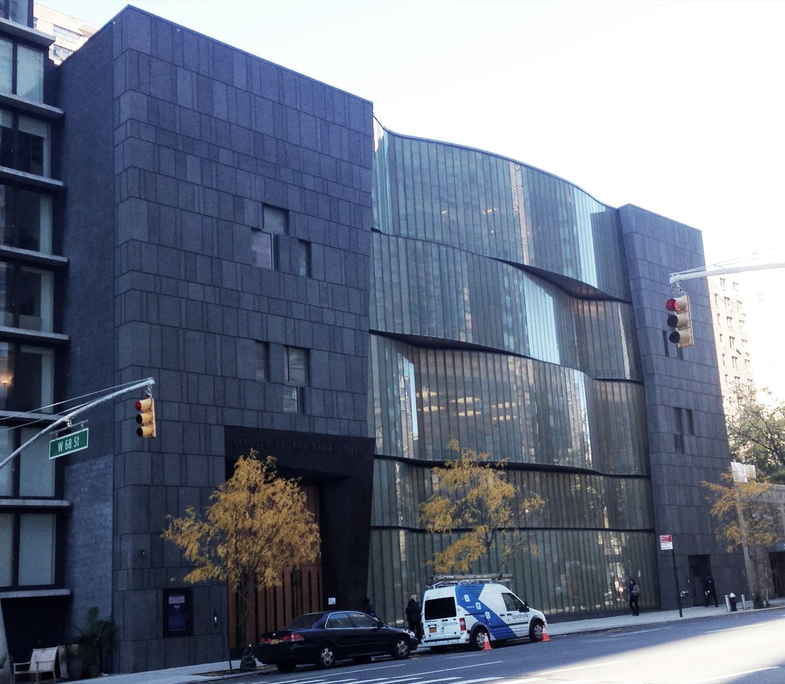 A dark stone and glass building on a street corner