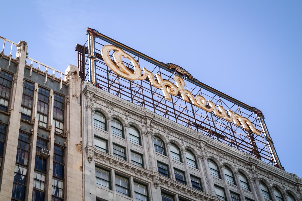 The tall vertical sign and Beaux-Arts front of the Orpheum Theatre on a downtown Los Angeles street