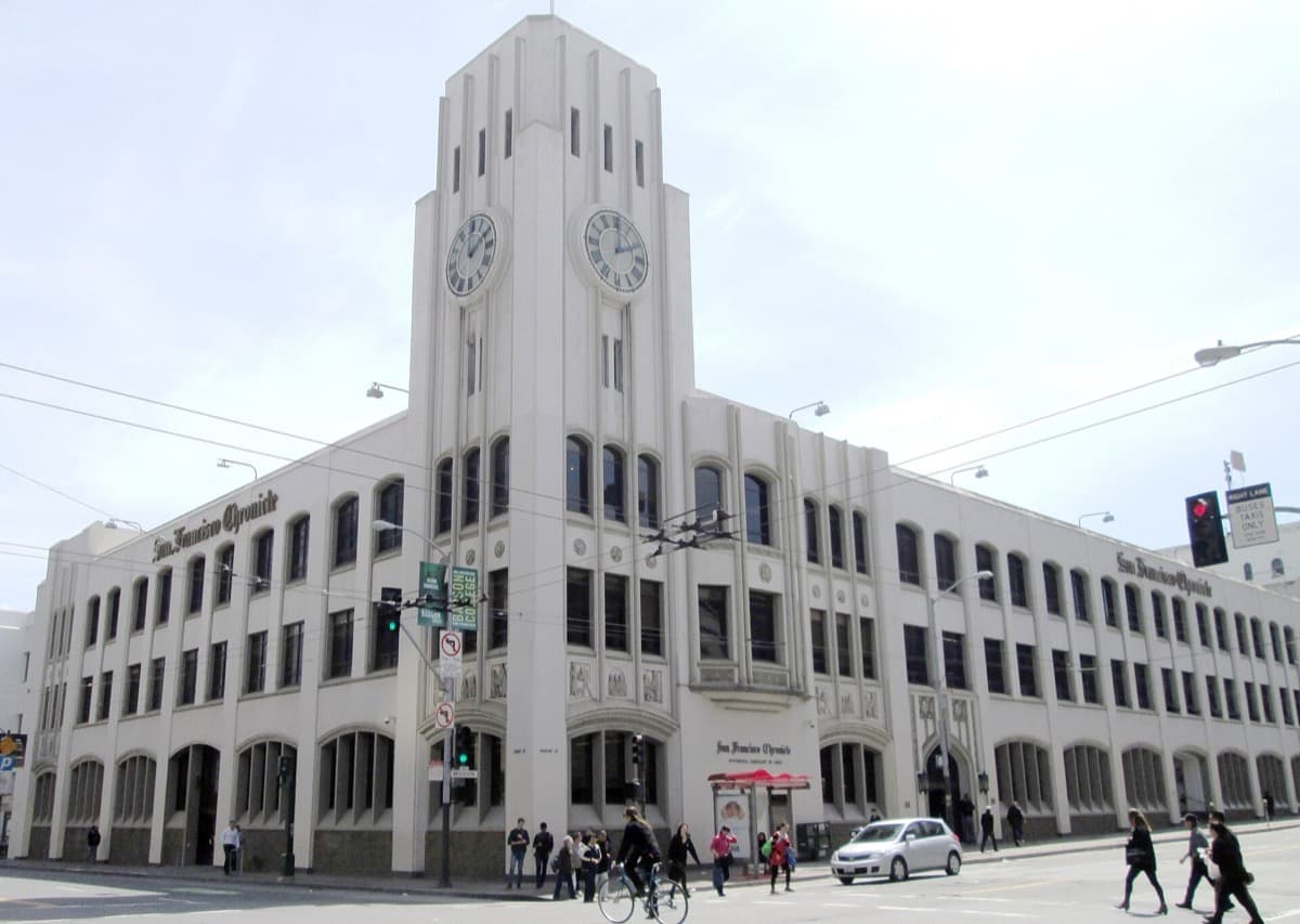A tall stucco-clad newspaper headquarters on a city corner