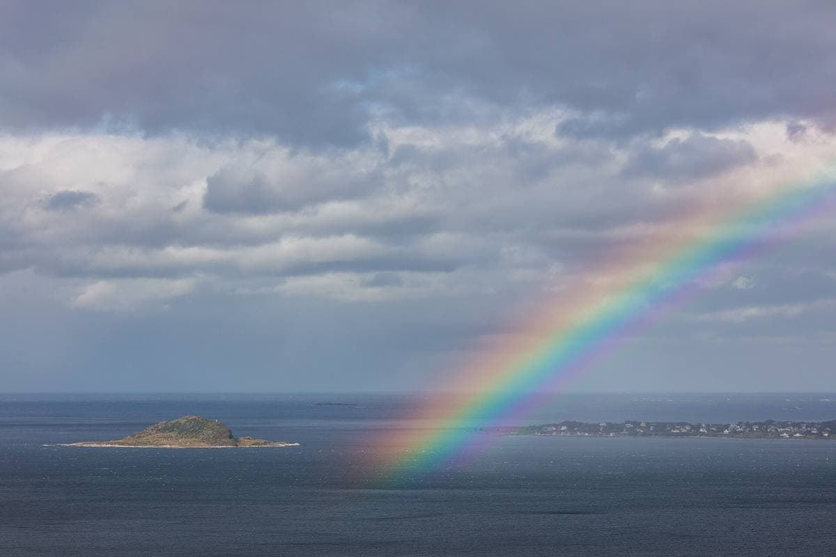 A rainbow over a rocky shore on the island of Giske