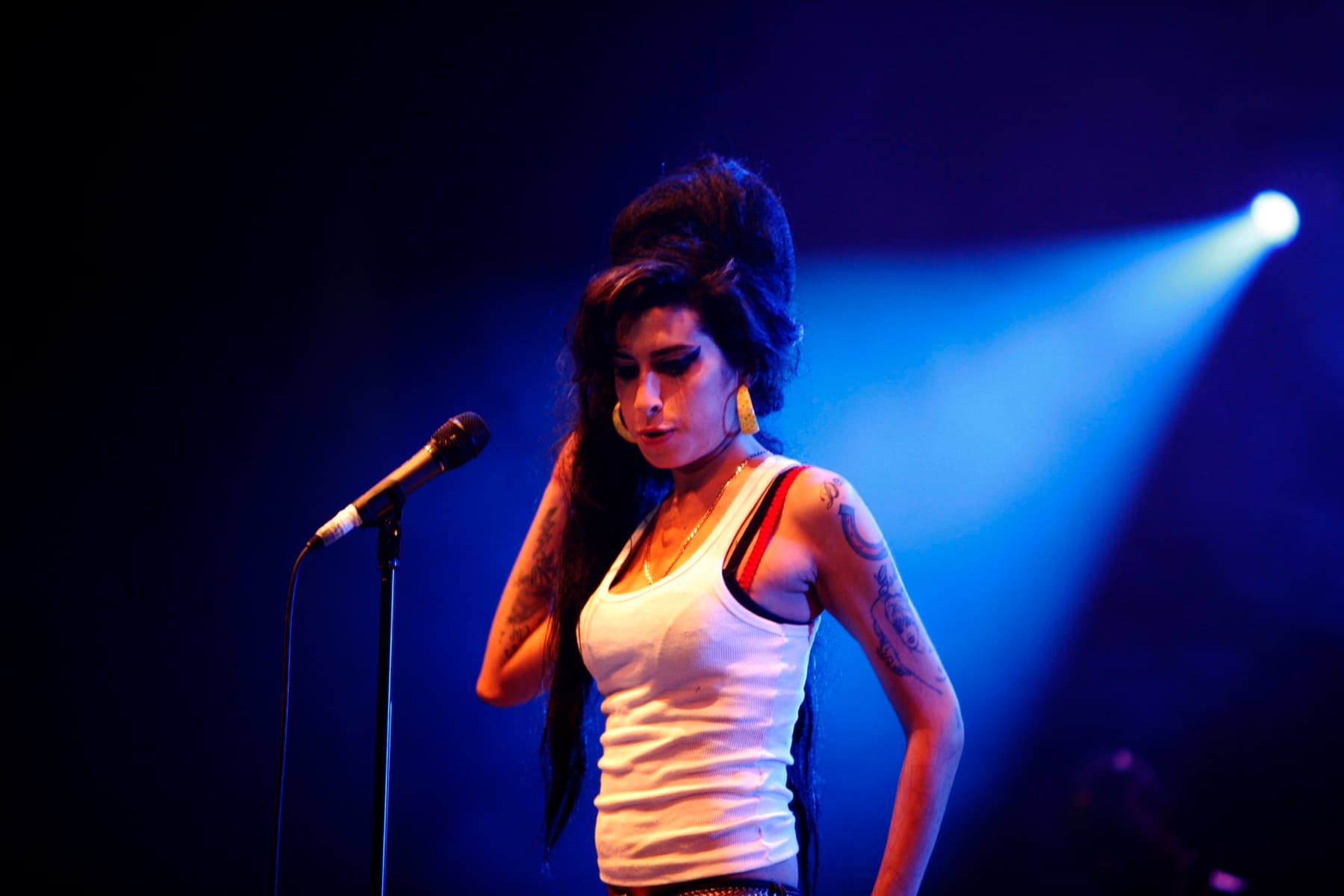 Amy Winehouse singing on stage, beehive high, eyes lined