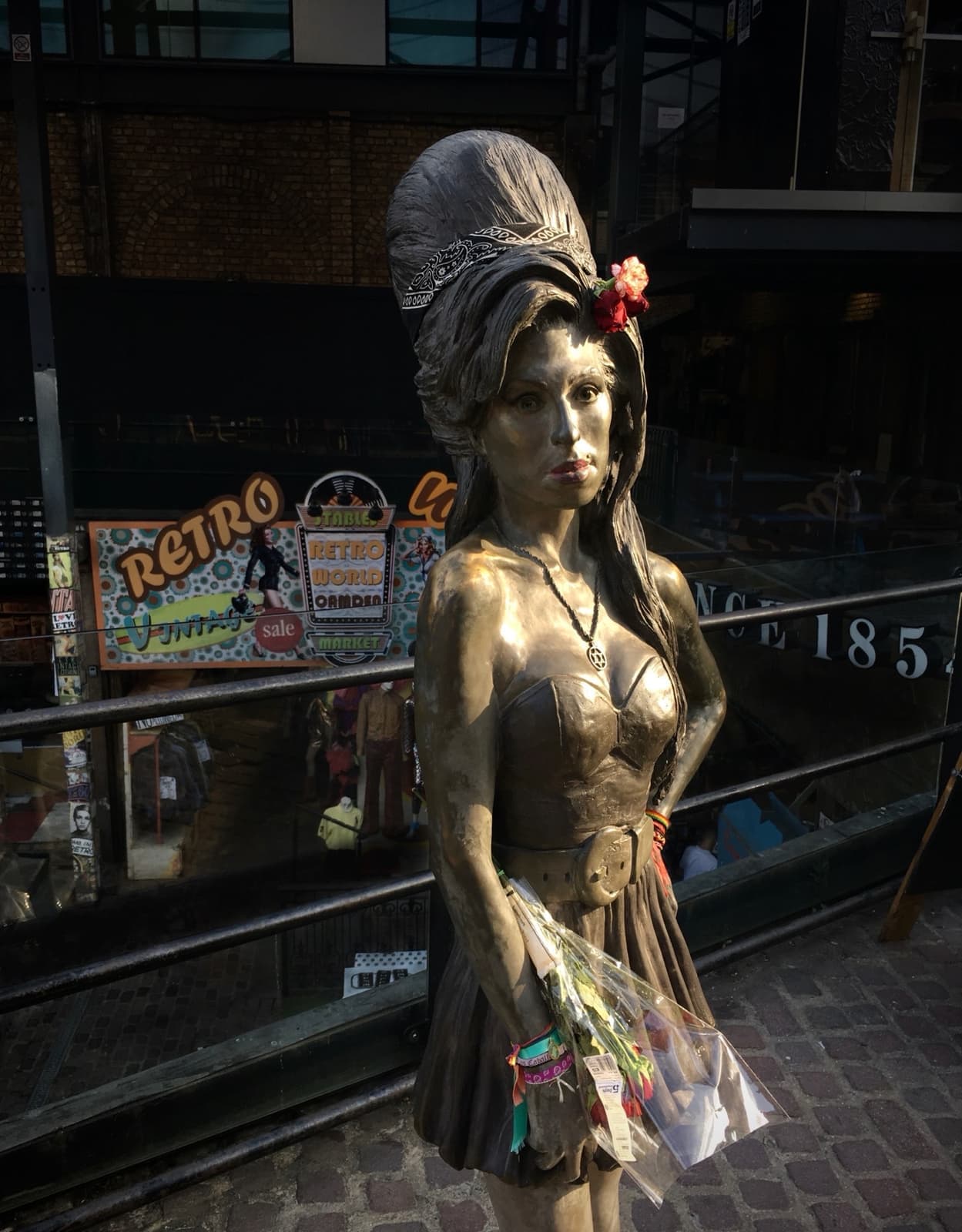 A life-size bronze of Amy Winehouse with a tall beehive, hand on hip