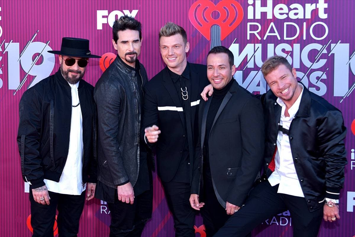 The five Backstreet Boys in suits on a red carpet, 2019