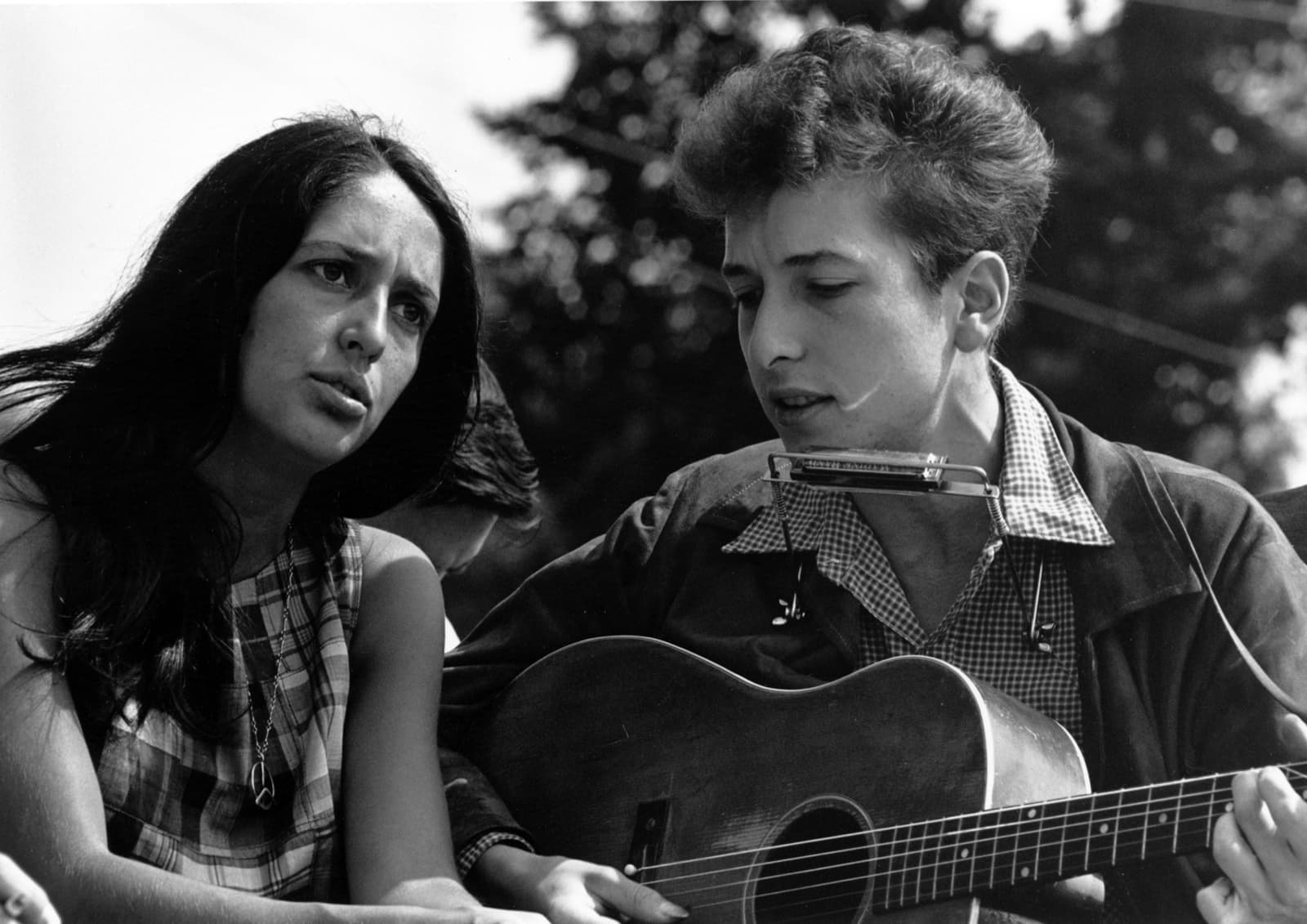 Joan Baez and Bob Dylan singing together outdoors