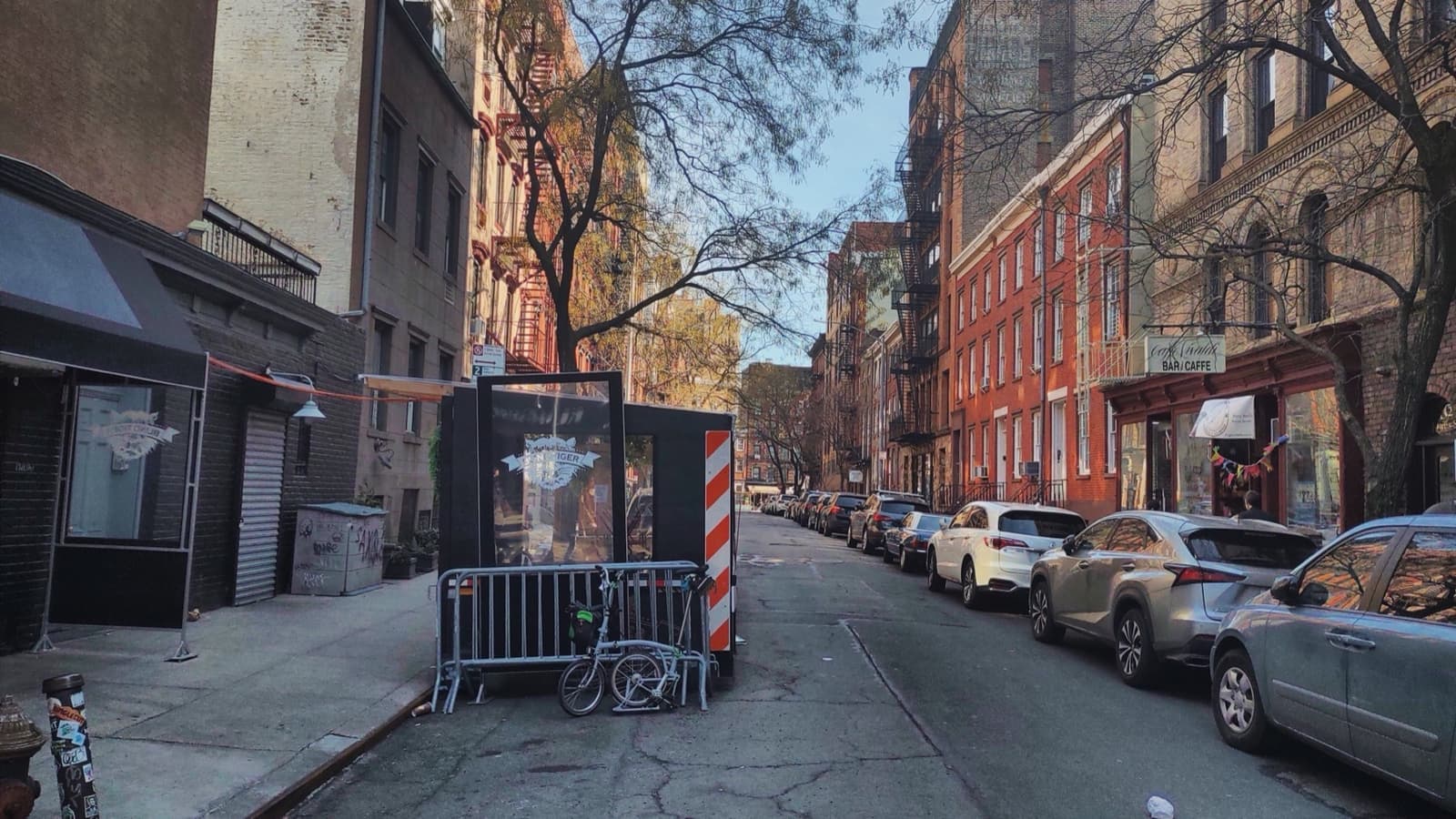 A narrow Greenwich Village street of brick walk-ups