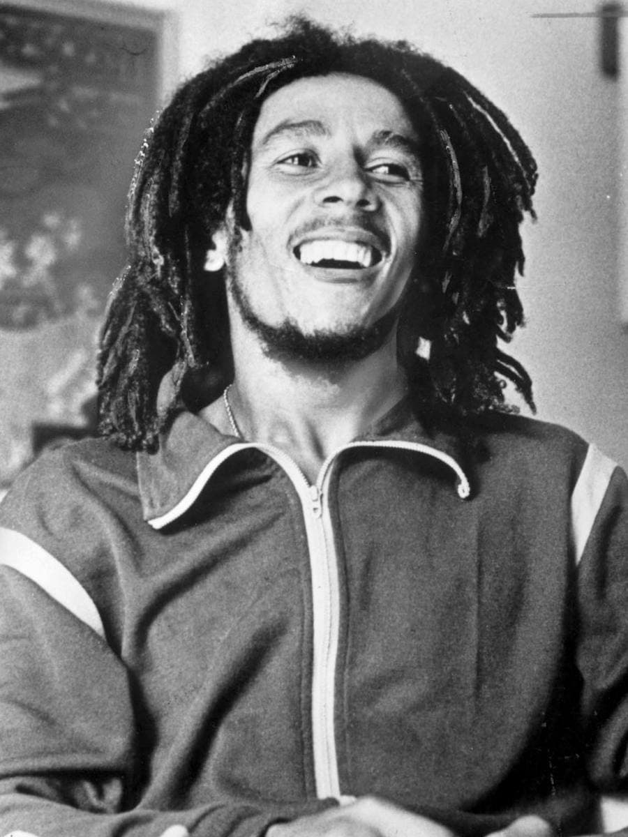 Bob Marley laughing, in a zipped track jacket