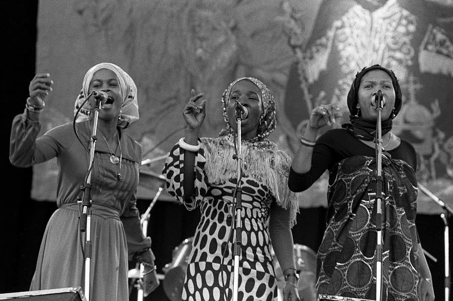 Three women singing together on stage: the I-Threes