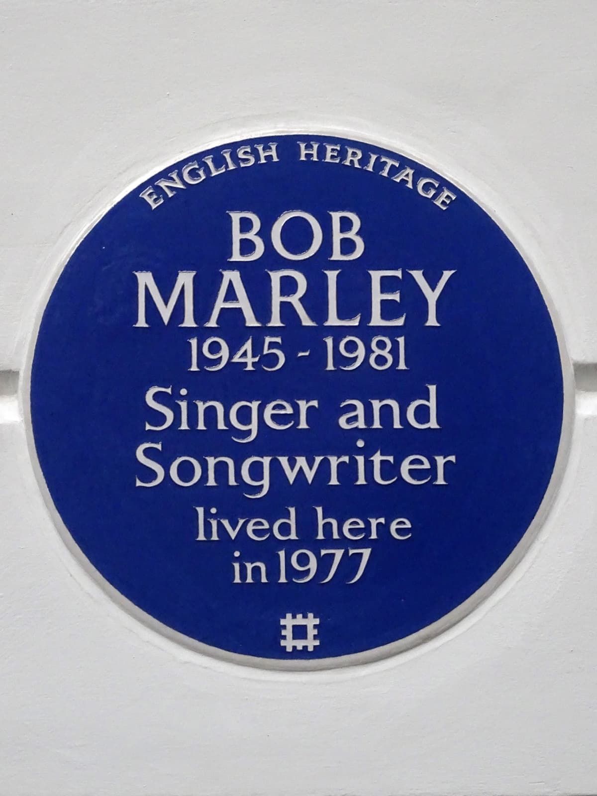 A blue plaque reading Bob Marley, lived here in 1977
