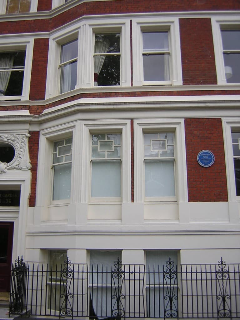 A blue plaque to Bob Marley on a red-brick mansion block