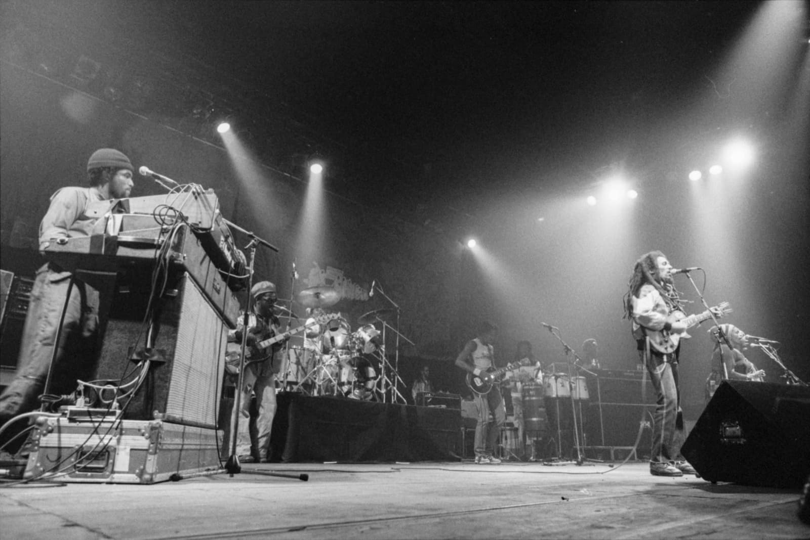 Bob Marley at the microphone with the Wailers behind him on a concert stage in Zürich, 1980
