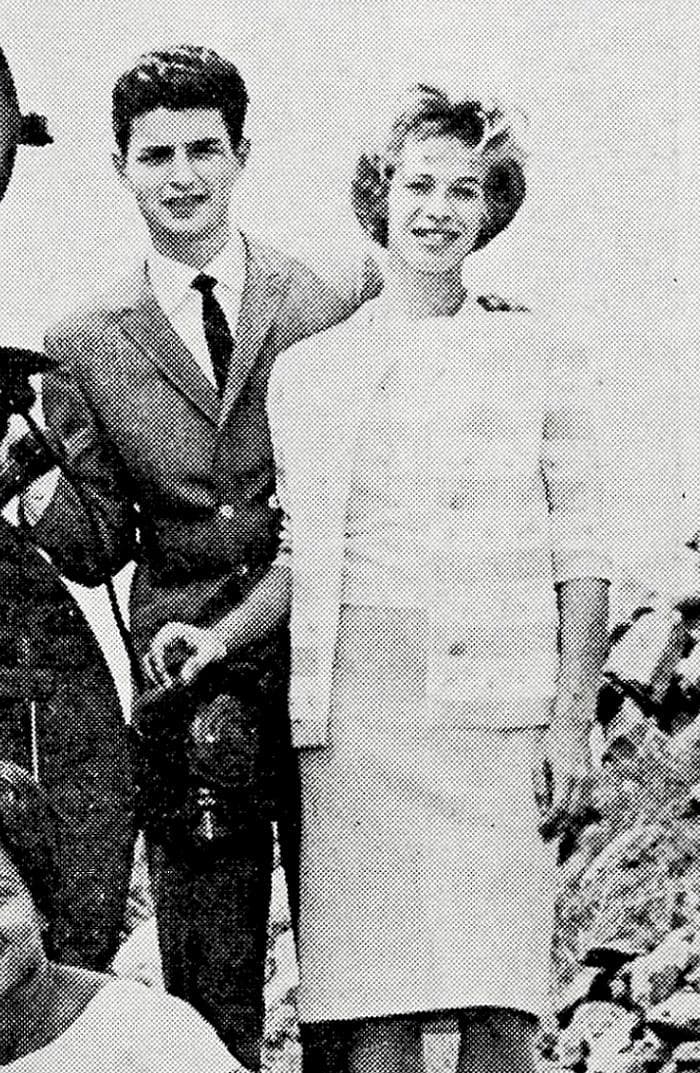 Gerry Goffin in a dark suit and Carole King in a pale jacket, standing on the front of a locomotive