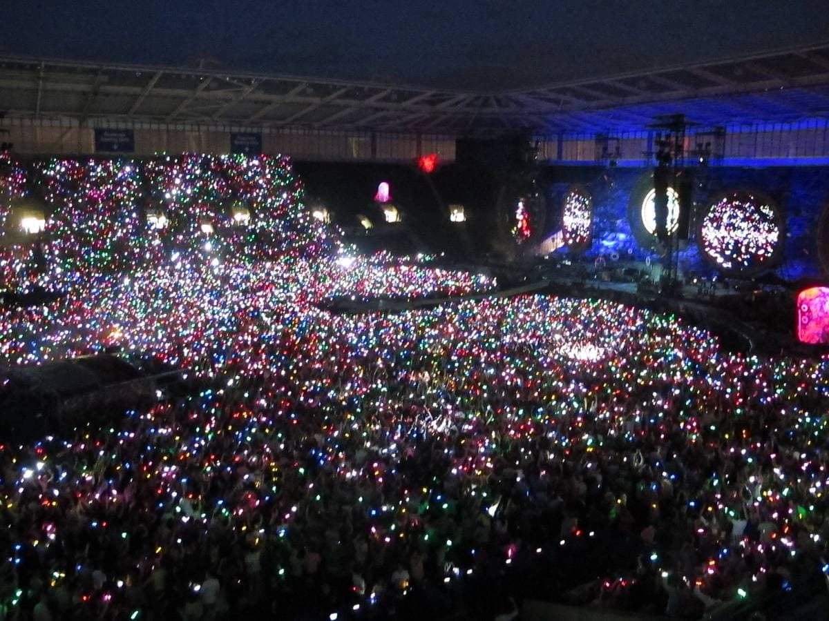 A stadium at night, the whole crowd speckled with points of coloured light