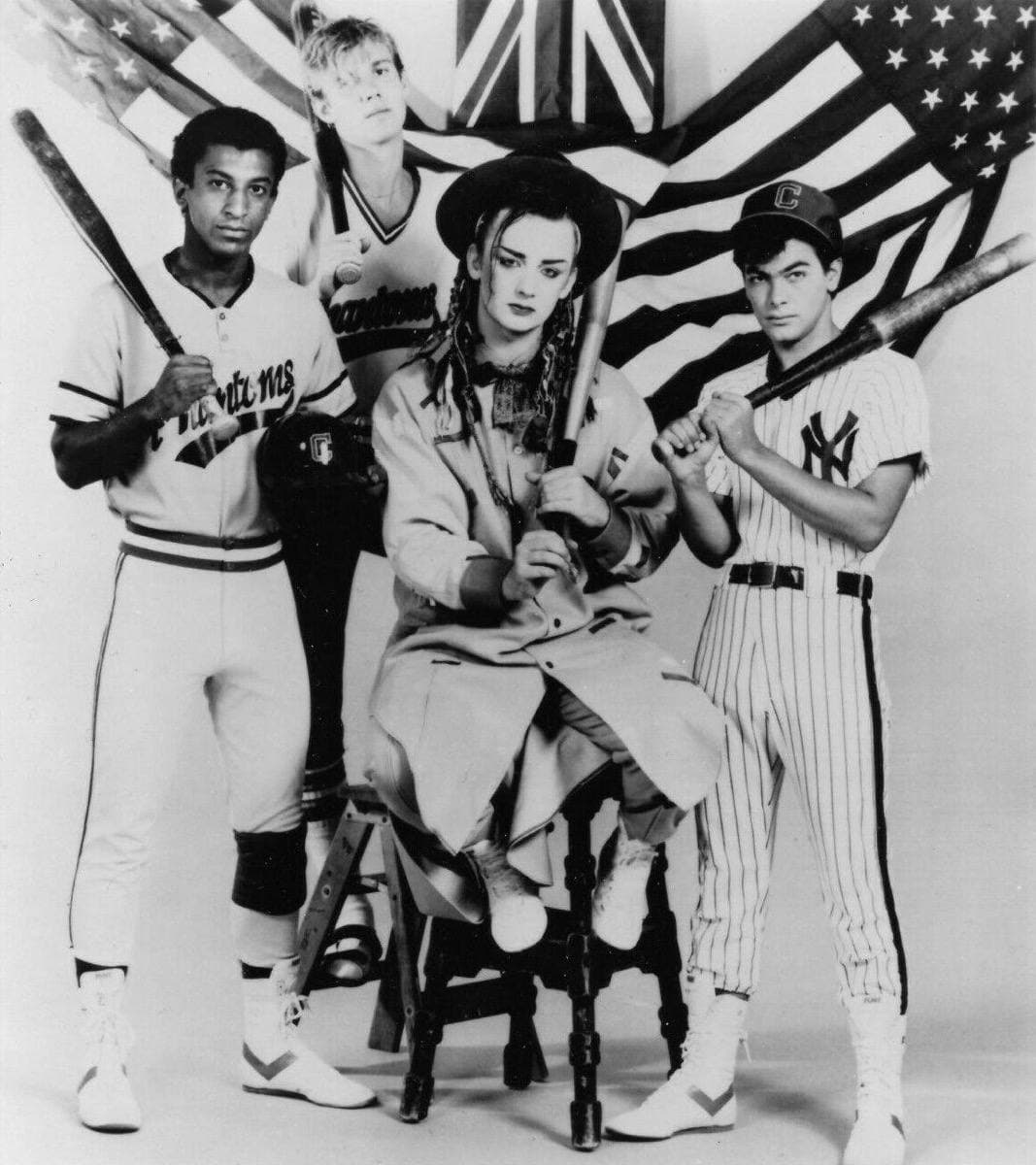 Culture Club posed in baseball shirts in front of British and American flags