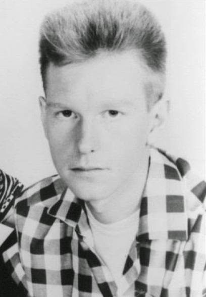 A tall young man with glasses, cropped from a group photograph