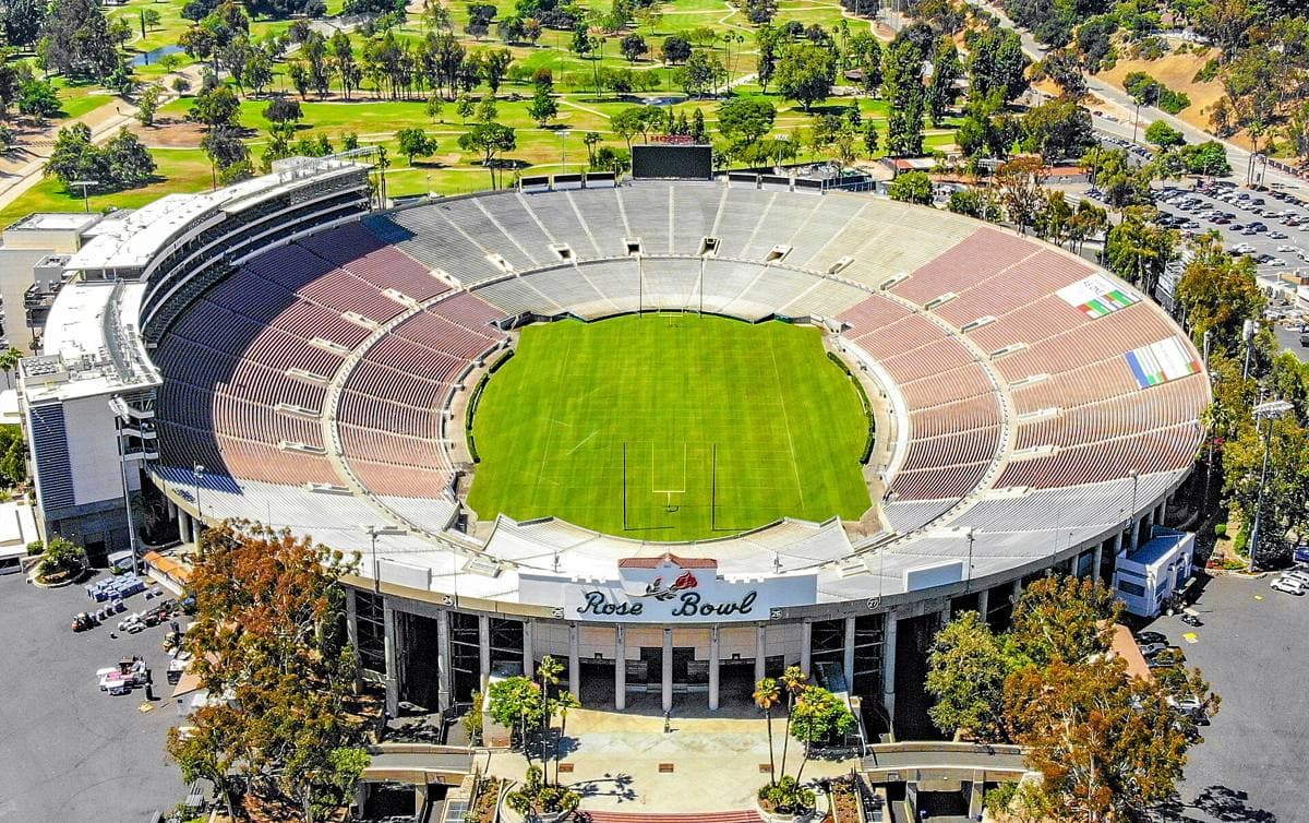 An aerial view of a large oval stadium in a green valley