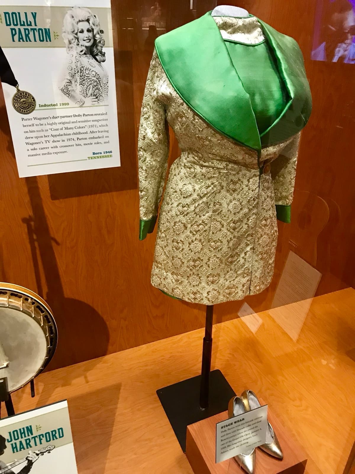 A brocade dress and coat with a high collar in a museum case