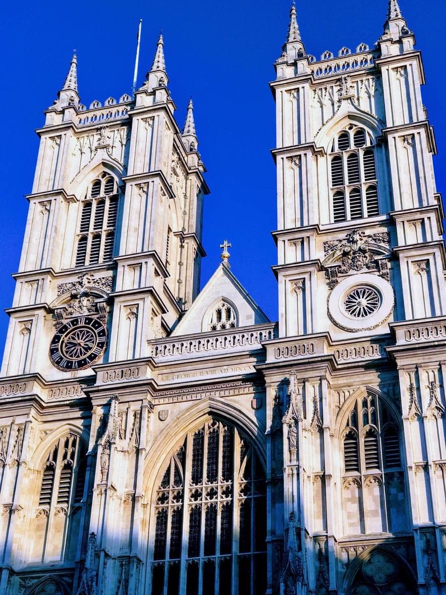 The twin Gothic towers of Westminster Abbey against a deep blue sky