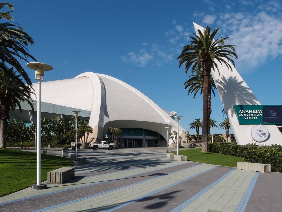 The curved white roof of the convention arena under a blue sky