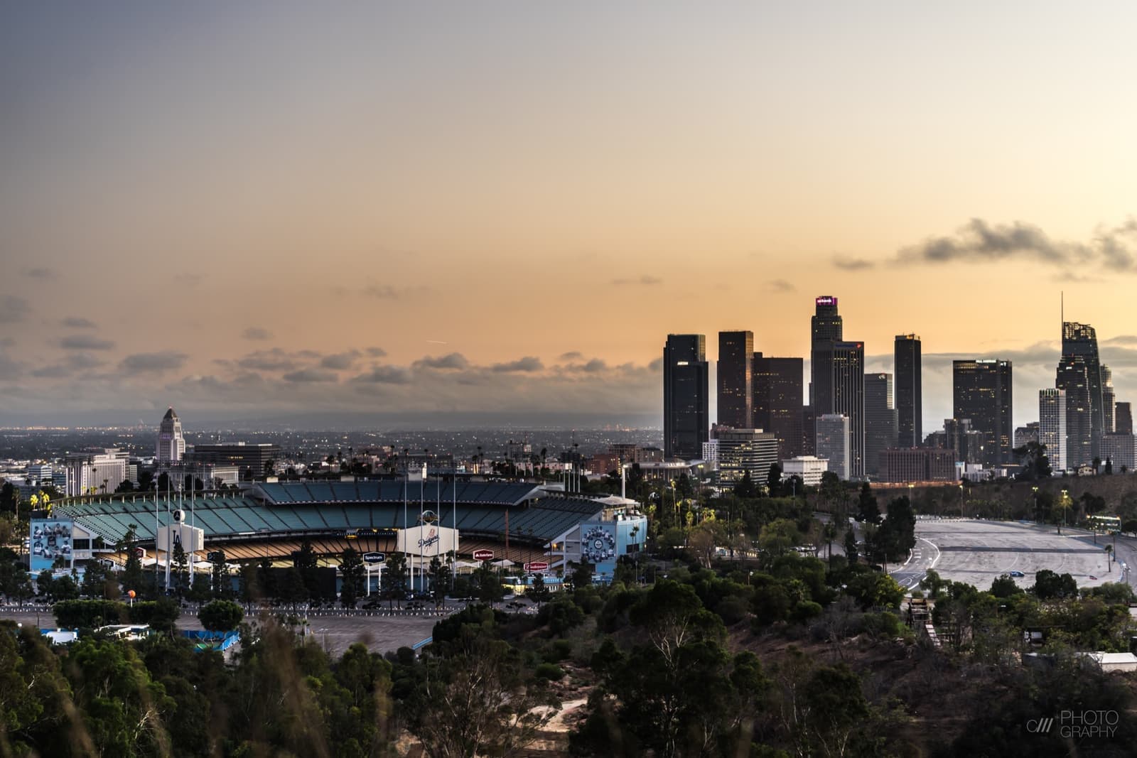 Dodger Stadium in the hills at dusk with the downtown Los Angeles towers behind