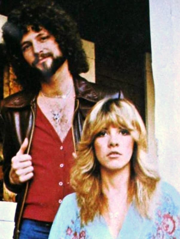 Lindsey Buckingham in a leather jacket standing behind Stevie Nicks in a pale embroidered blouse