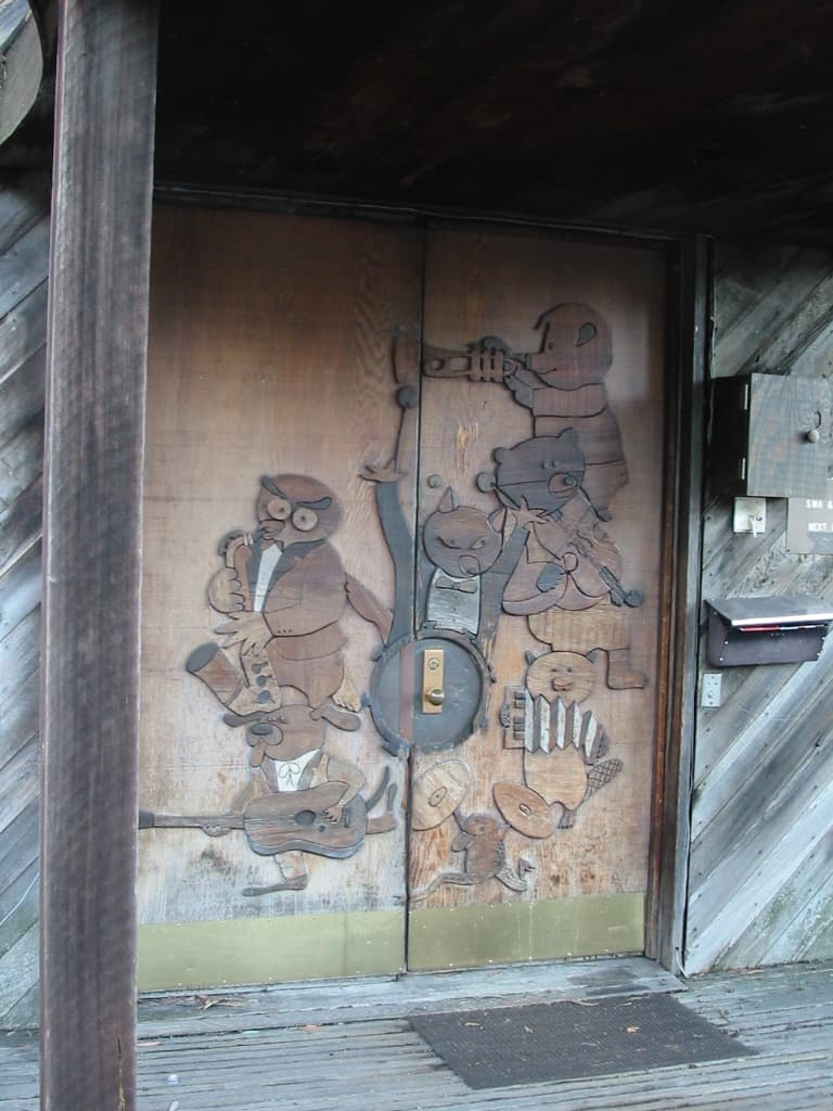 A carved wooden door panel showing animals playing musical instruments