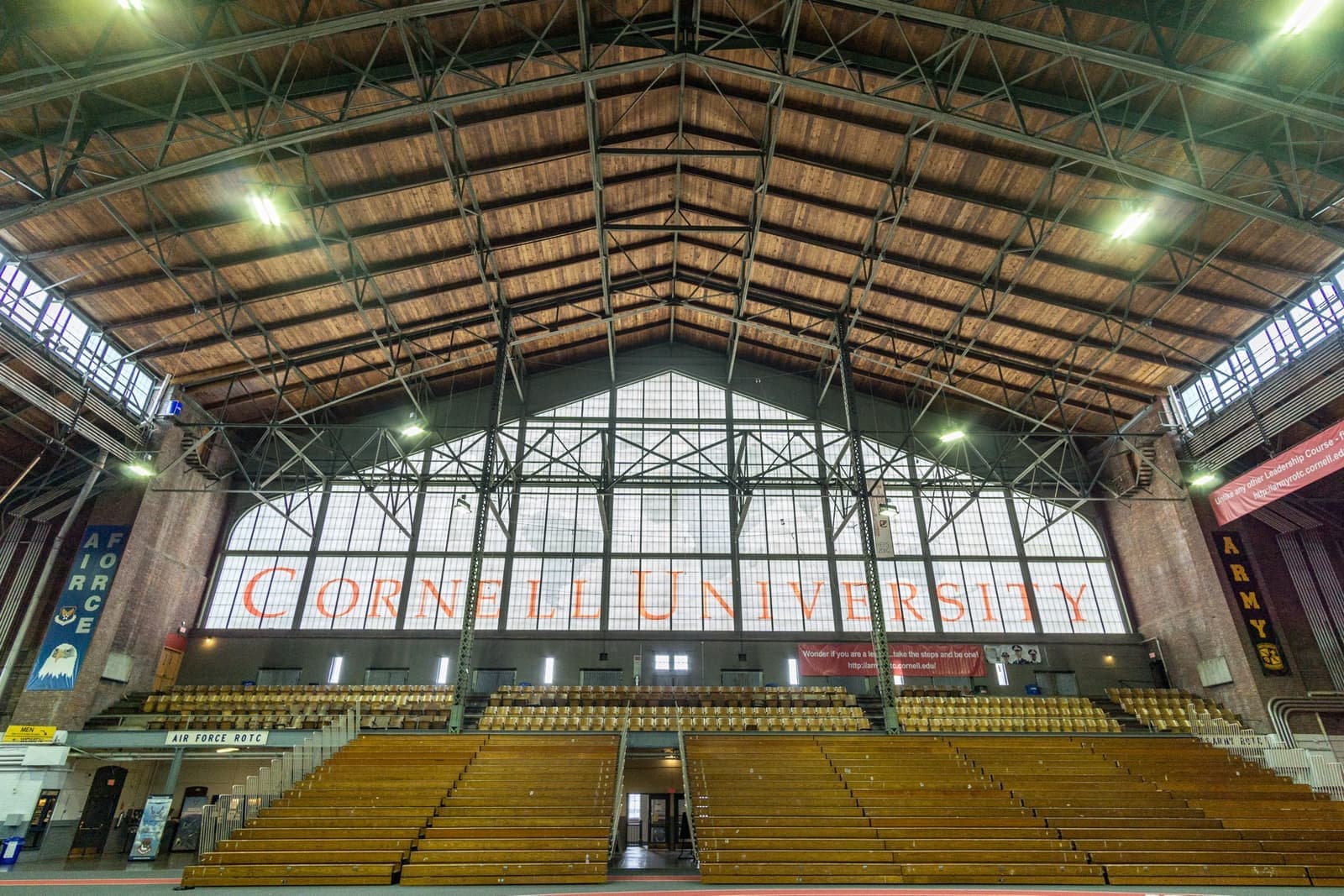 A vast hall under steel roof trusses, a wall of windows at the far end