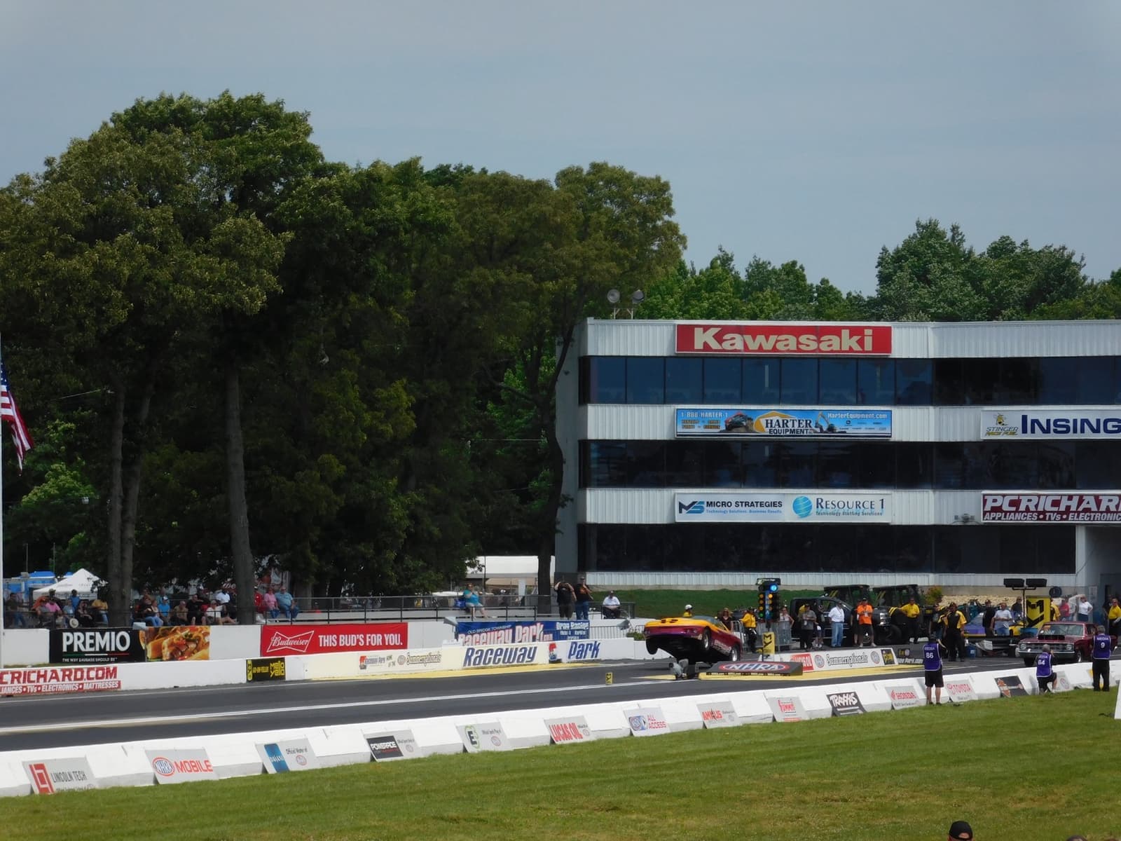 A drag strip start line with a tower of sponsor boards behind